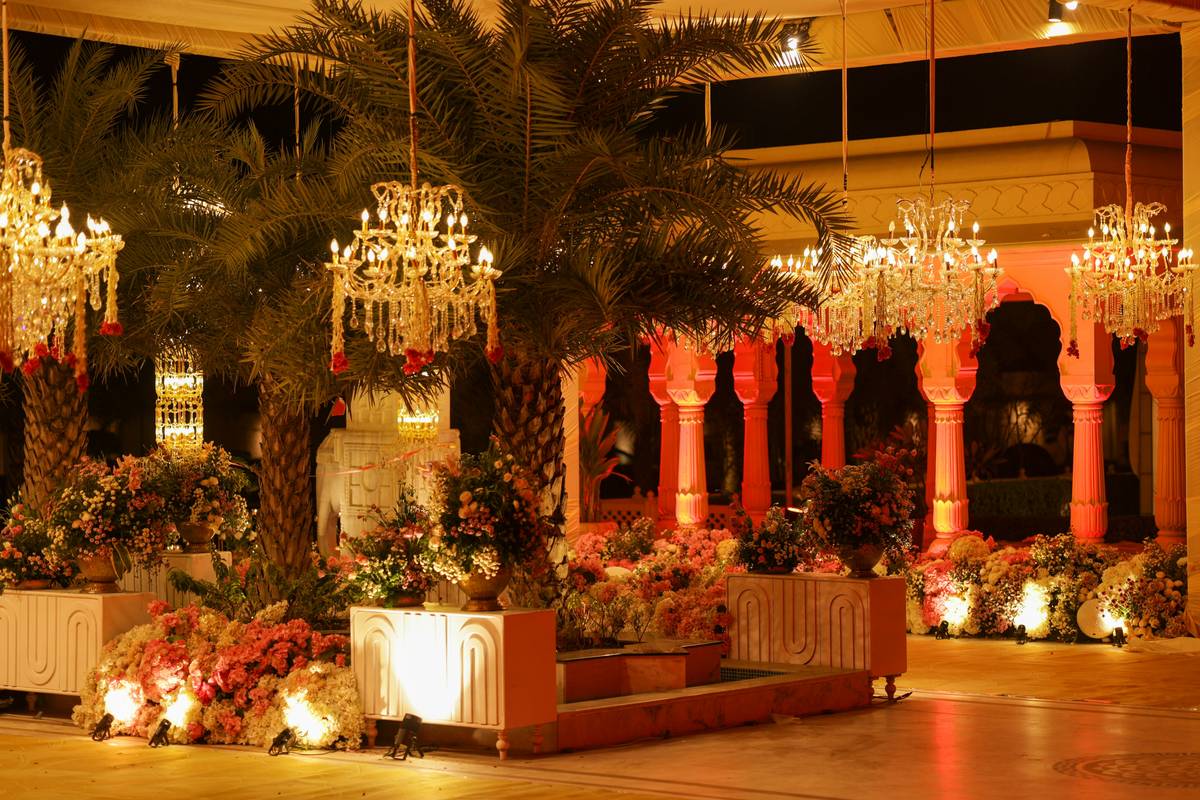 services based wedding decor featuring elegant draped linens, curated floral arrangements, and ambient string lighting in a garden venue